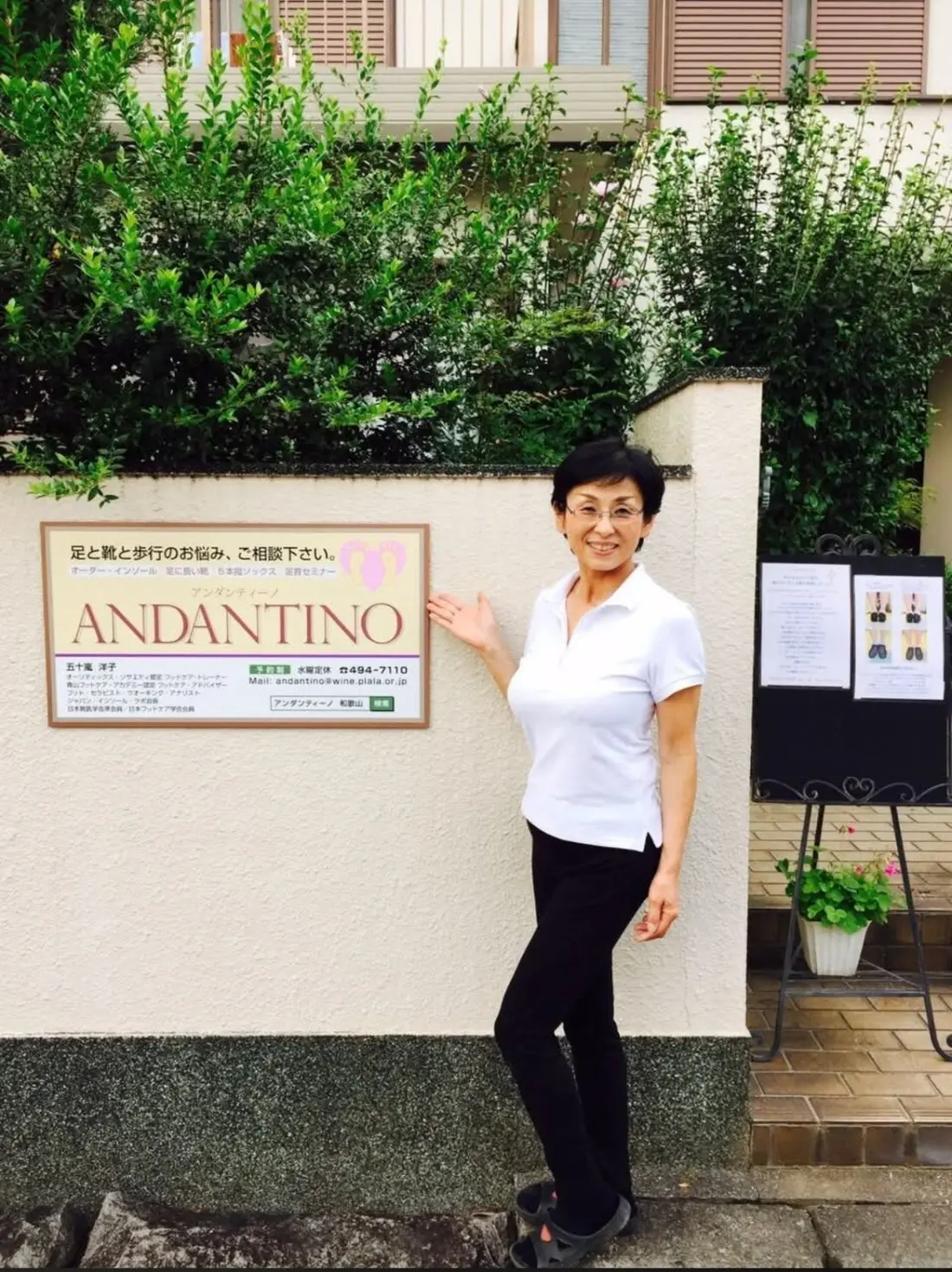 ANDANTINOの看板前に立つ代表・シューフィッターの五十嵐洋子